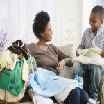 Black mother and son folding laundry